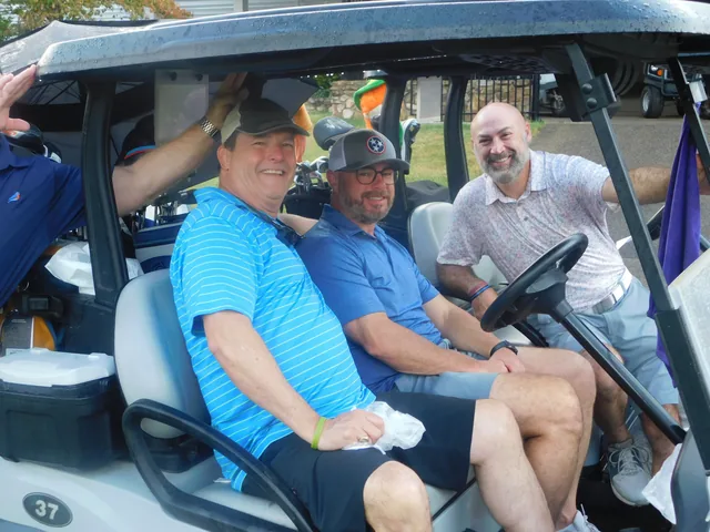 Golfers posing together in their golf cart at COMEC’s 2026 golf tournament