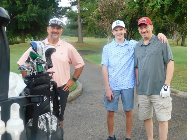 Golfers gathering beside their clubs and cart at COMEC’s 2026 golf tournament