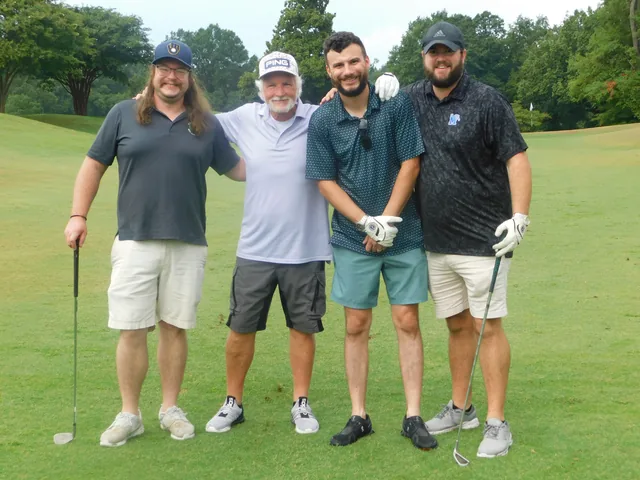 A four-person team enjoying the tournament at COMEC’s 2026 golf tournament