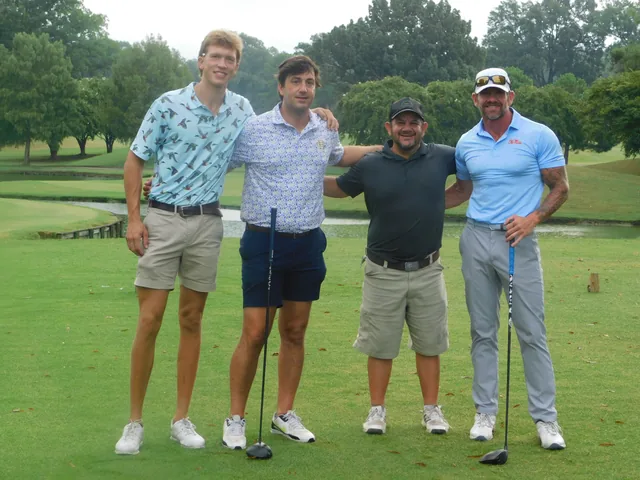 A golf team posing together on the course at COMEC’s 2026 golf tournament