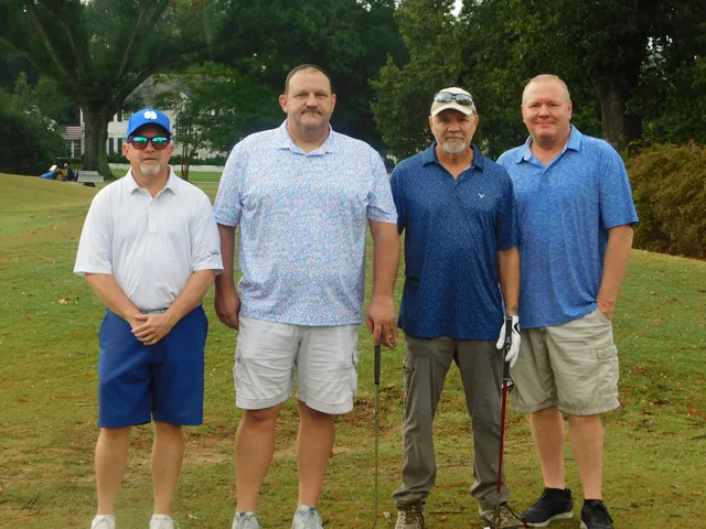 A four-person team taking a break for a photo at COMEC’s 2026 golf tournament