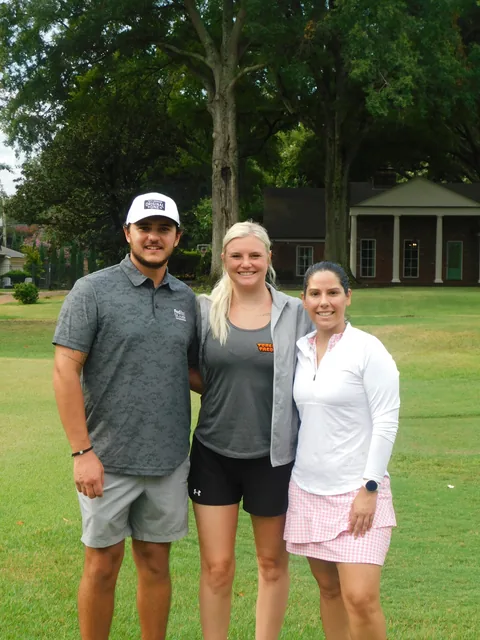 Three players smiling beside a golf cart at COMEC’s 2026 golf tournament