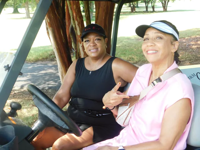 Two golfers smiling from their cart at COMEC’s 2026 golf tournament