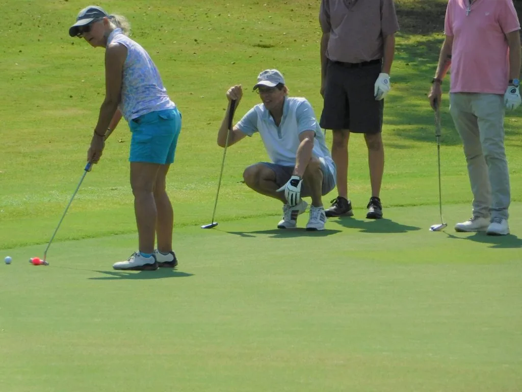 Golfers lining up a putt during a COMEC Golf Tournament
