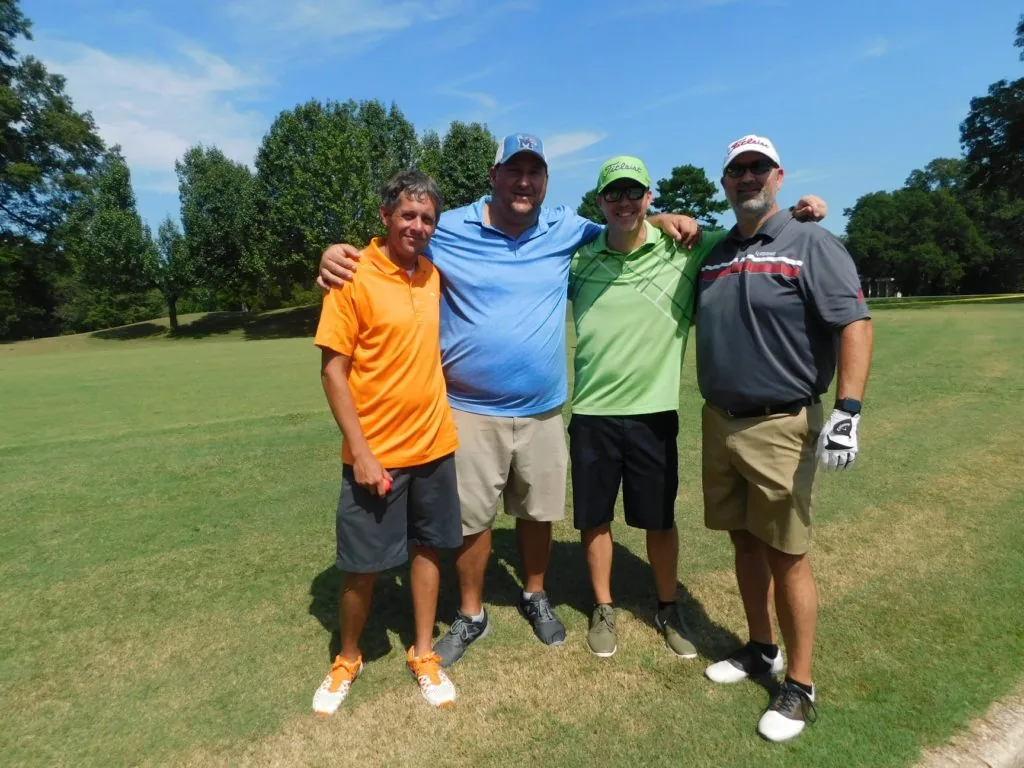 Four golfers in colorful shirts at a COMEC Golf Tournament